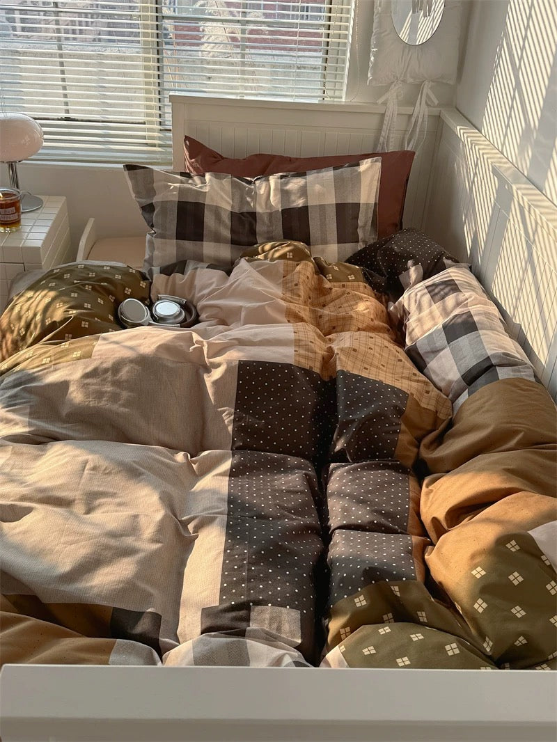 Bed with patterned pillows and blankets in a sunlit room