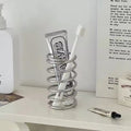 Holder displayed on a bathroom countertop with toothbrushes and toothpaste