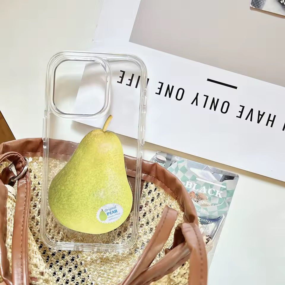 Clear phone case with a pear inside, placed on a woven surface with a magazine underneath.