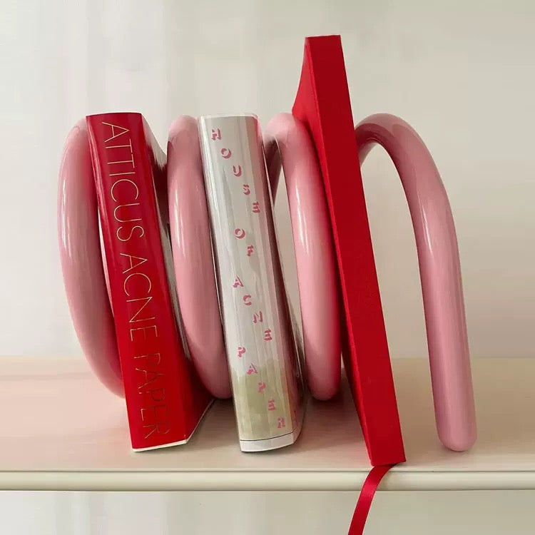 Three books stacked on a shelf with visible titles