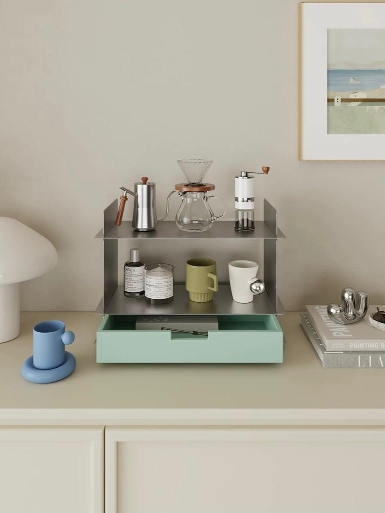 Mint green desk shelf with a drawer holding a pour over coffee set, a candle and mugs on a cream counter