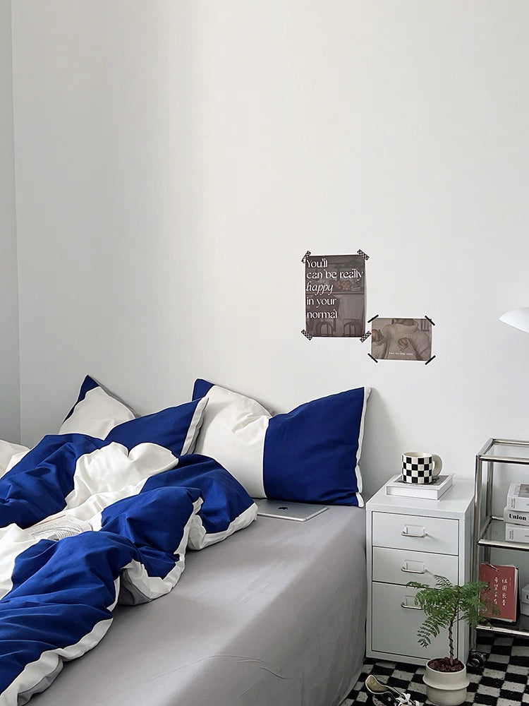 Bed with blue and white bedding in a bedroom setting.
