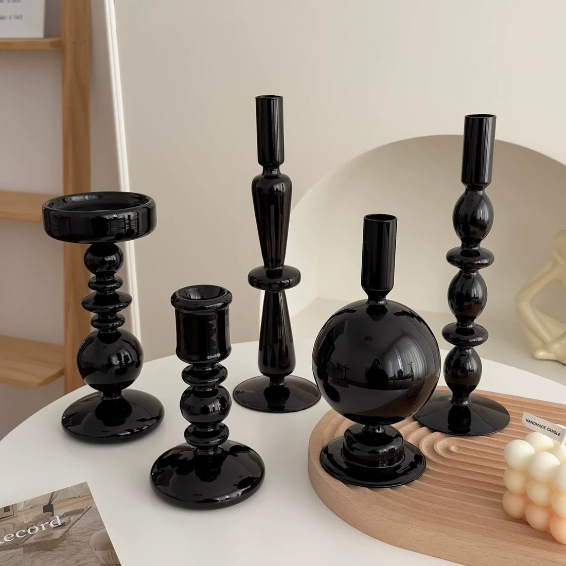 Set of black candle holders on a table with a neutral background