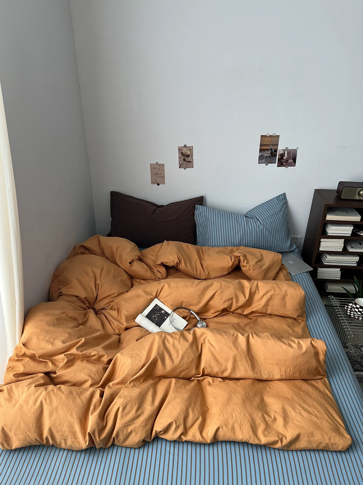 Front view of the orange bedding set with blue striped and brown pillowcases