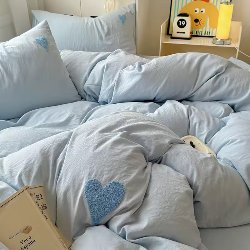 Close-up of blue cotton duvet with cozy texture and embroidered heart detail