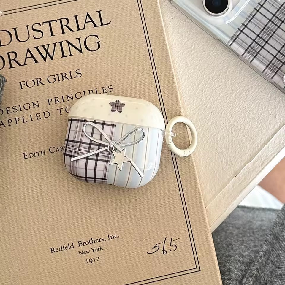 White earphone case with plaid design on a vintage book