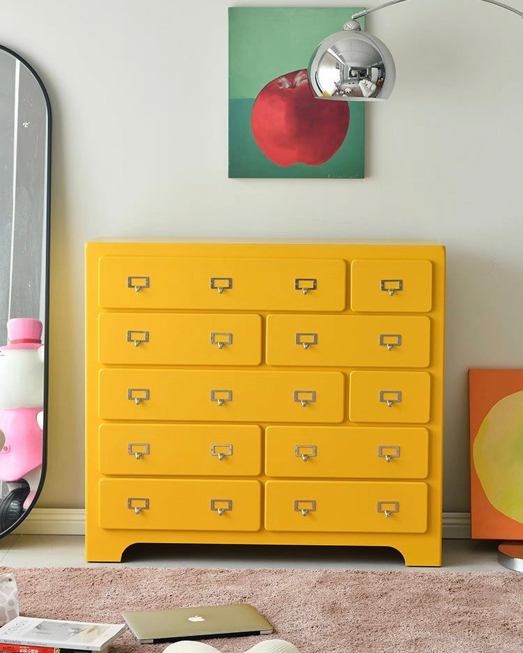 Dopamine pink ten drawer cabinet styled with decor items in modern interior room