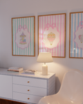 Decorative wall art with striped frames and a lamp on a dresser.