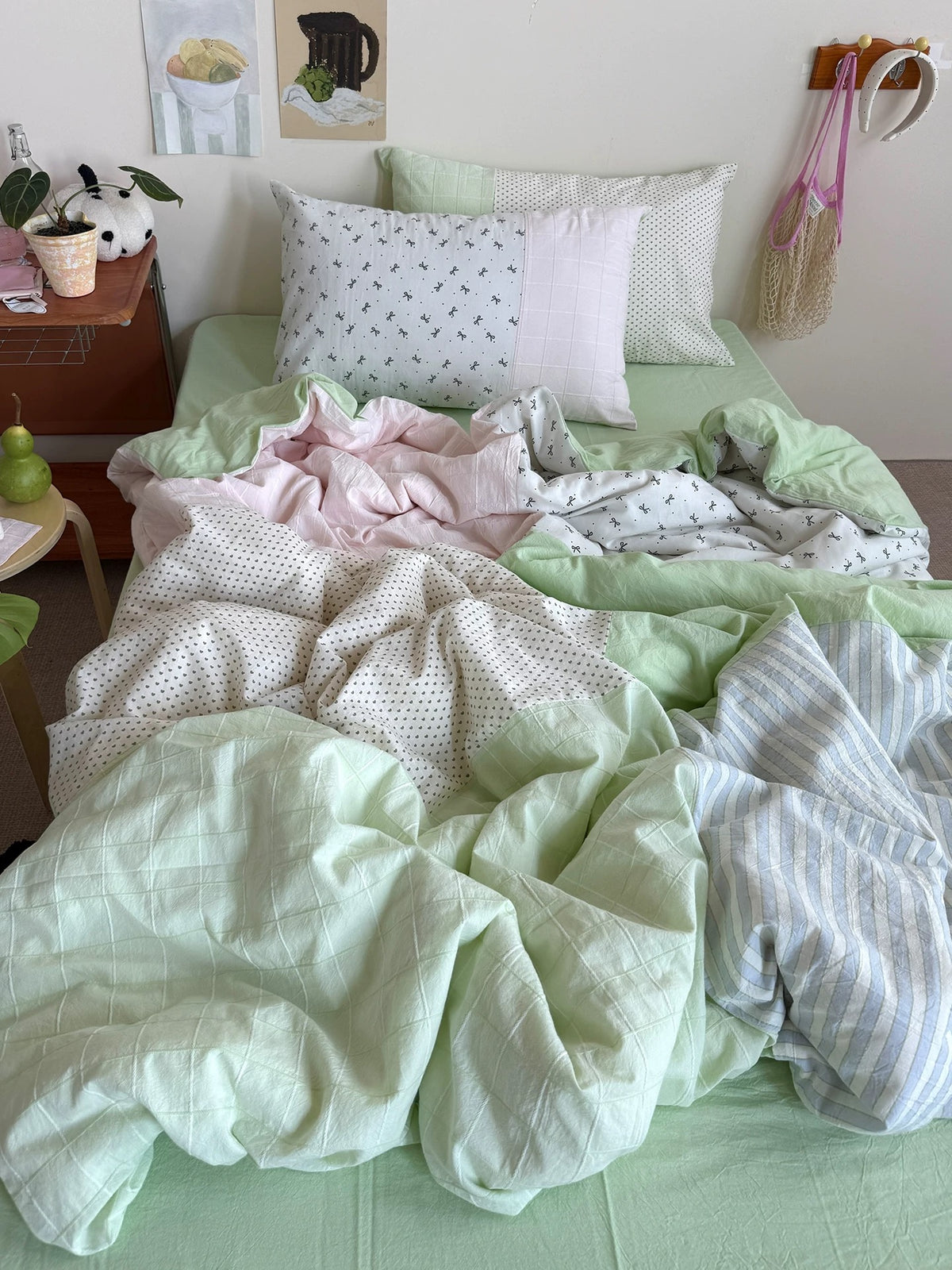 Pink and green patchwork duvet cover styled with a plant beside the bed