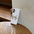 Phone case with a bow design on a wooden surface