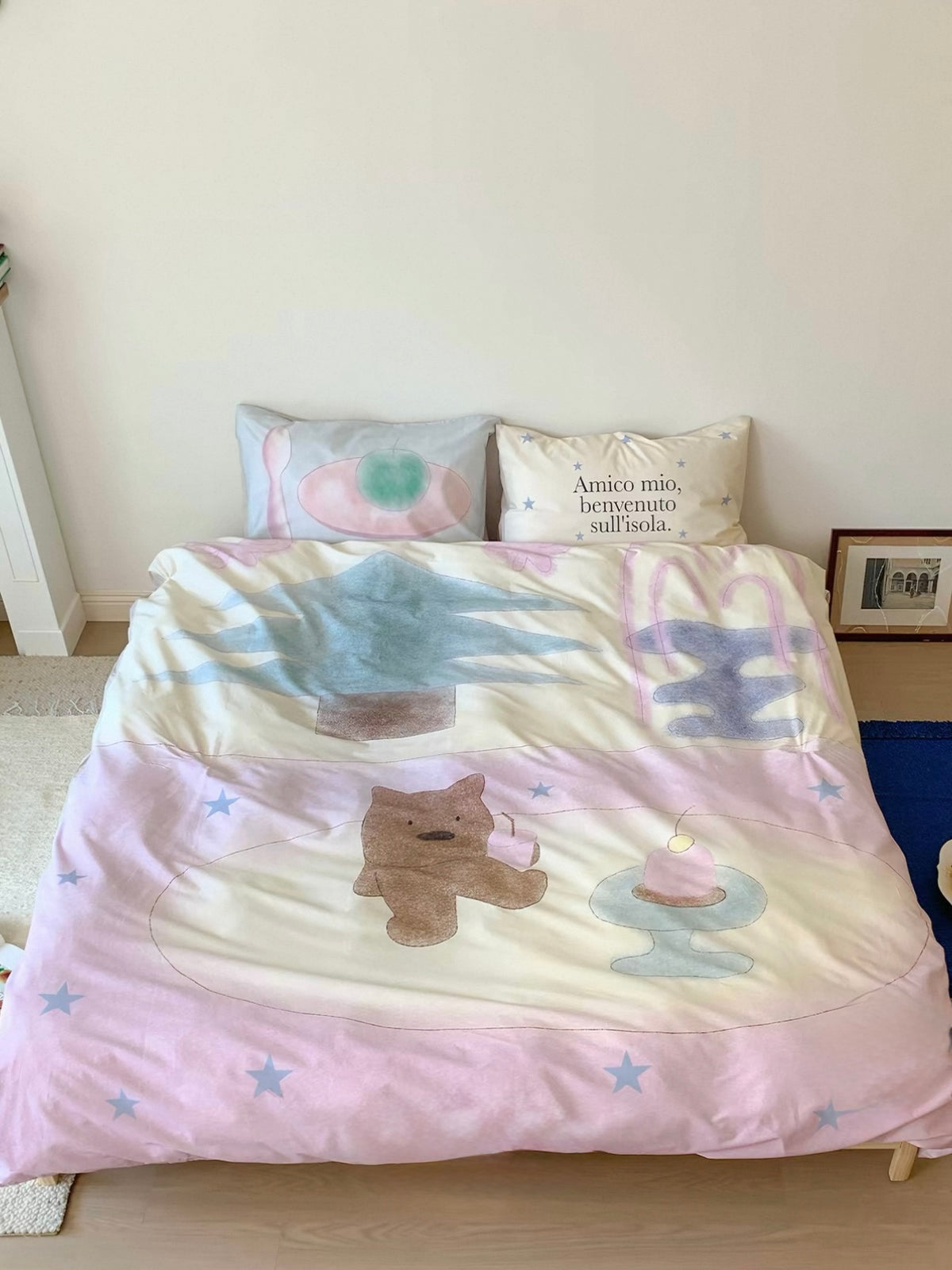 Pink teddy bear bedding shown from the front with pastel tableware shapes and stars.