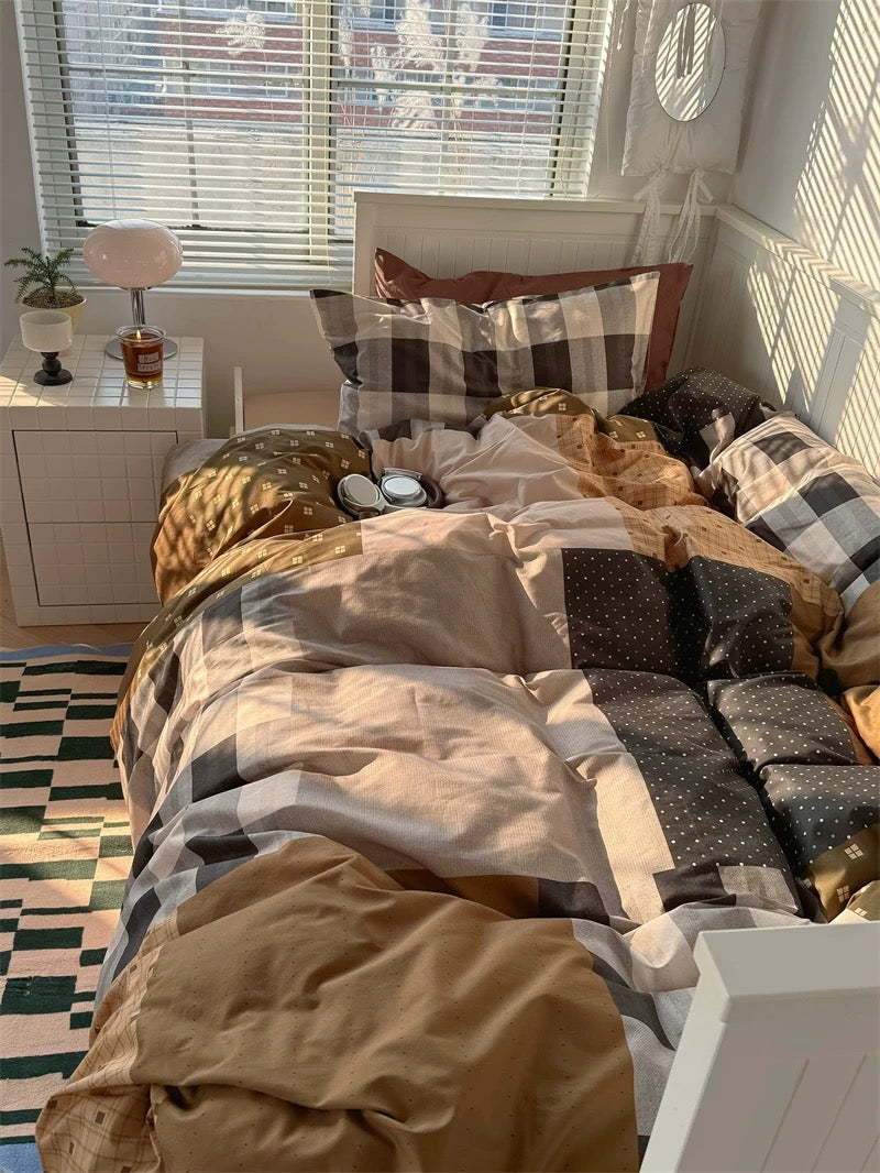 Bedroom with a bed covered in patterned bedding, nightstand, and window blinds.