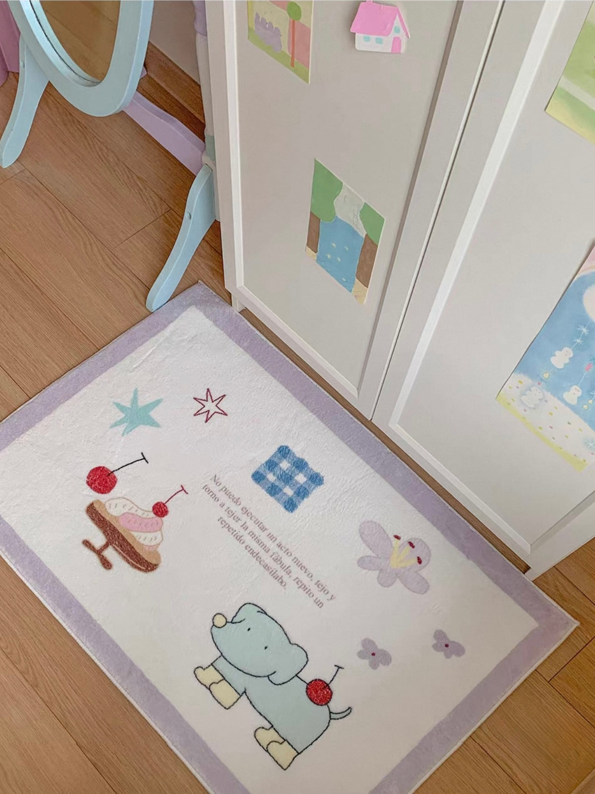 A purple cherry rug lies at an angle, showing a green cartoon animal, a dessert and scattered star and flower motifs.