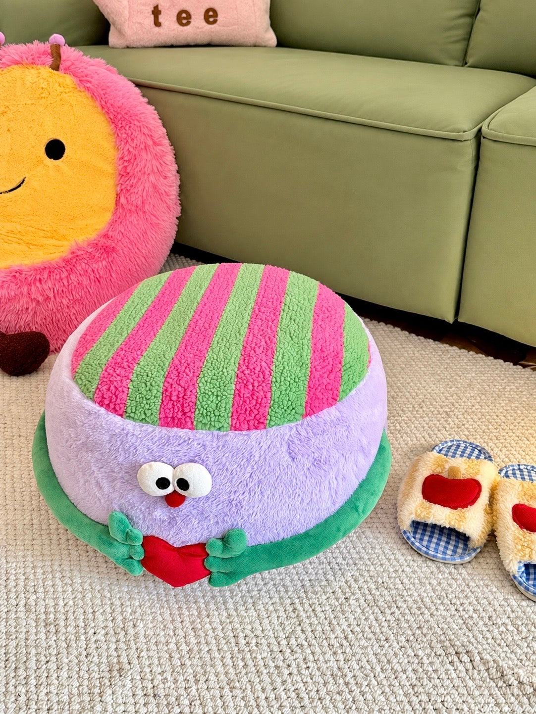 Purple striped pouf ottoman with green arms and heart detail