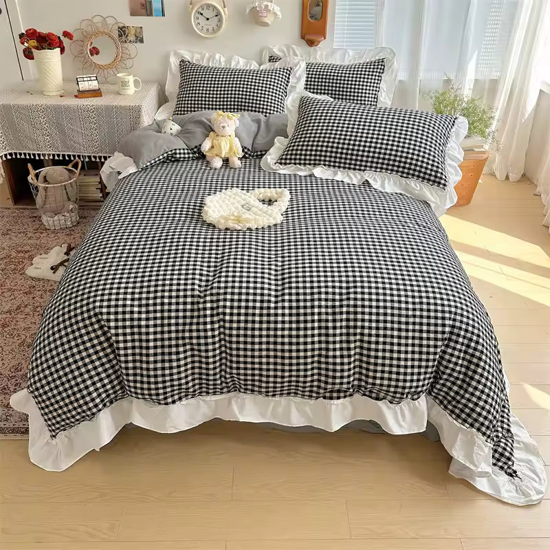 Black and white checkered bedspread with ruffled edges on a bed in a bright room.