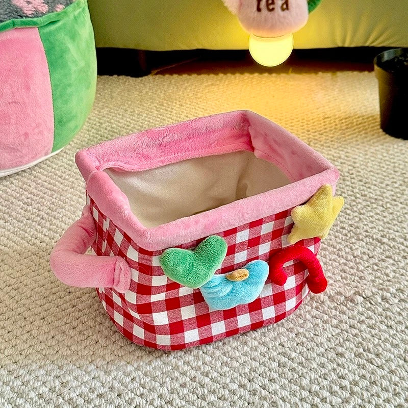 Red plaid storage basket open with pink rim and colorful decorative shapes