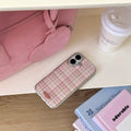 Pink aesthetic phone case lying next to pastel books and a latte cup for cozy desk setup