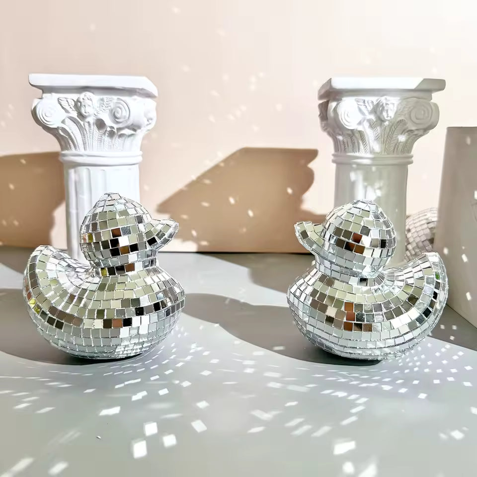 Decorative disco duck figurines on columns against a beige background