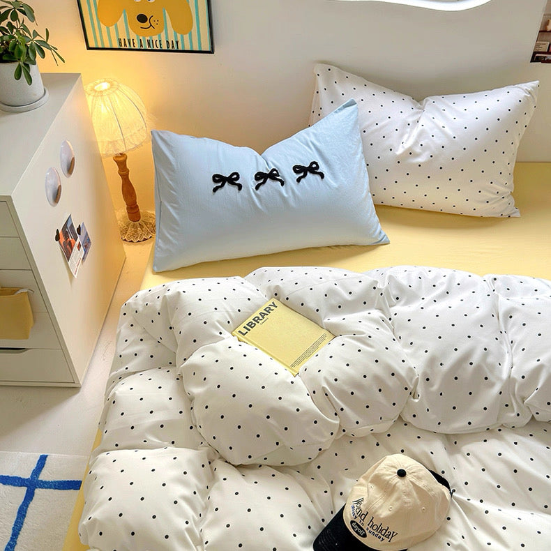 Close-up of polka dot pillowcase and textured cotton comforter