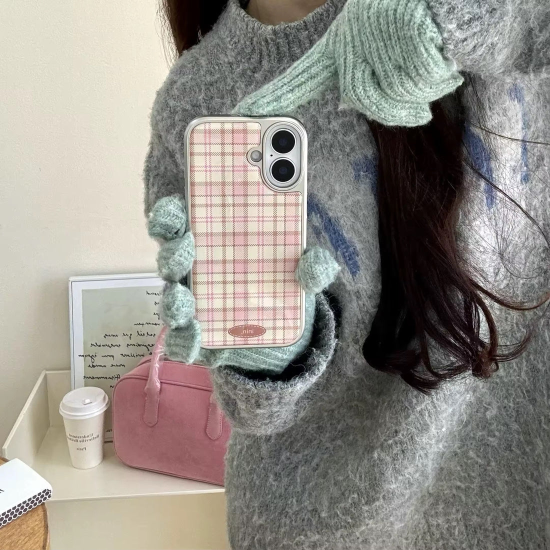 Close-up of Korean plaid iPhone case with brown checkered leather design and soft girl gloves