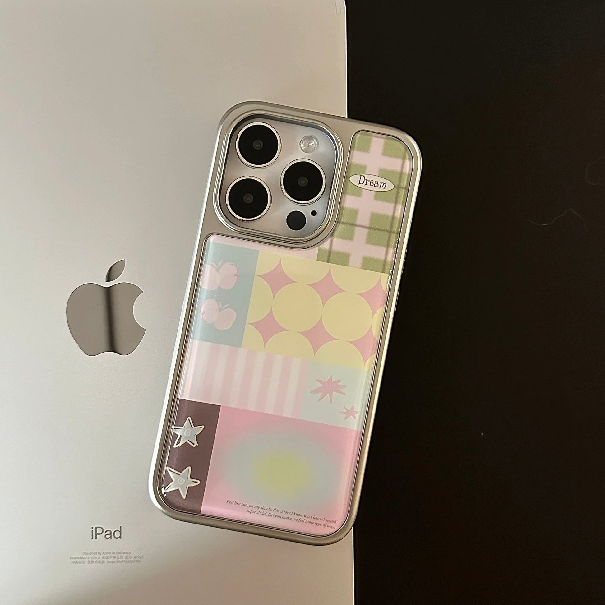 Close-up of pastel glossy phone case with Y2K pattern blocks and dreamy symbols