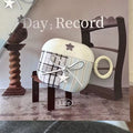 Decorative item with plaid pattern and star design on a wooden stand, with 'Day Record Life' text.