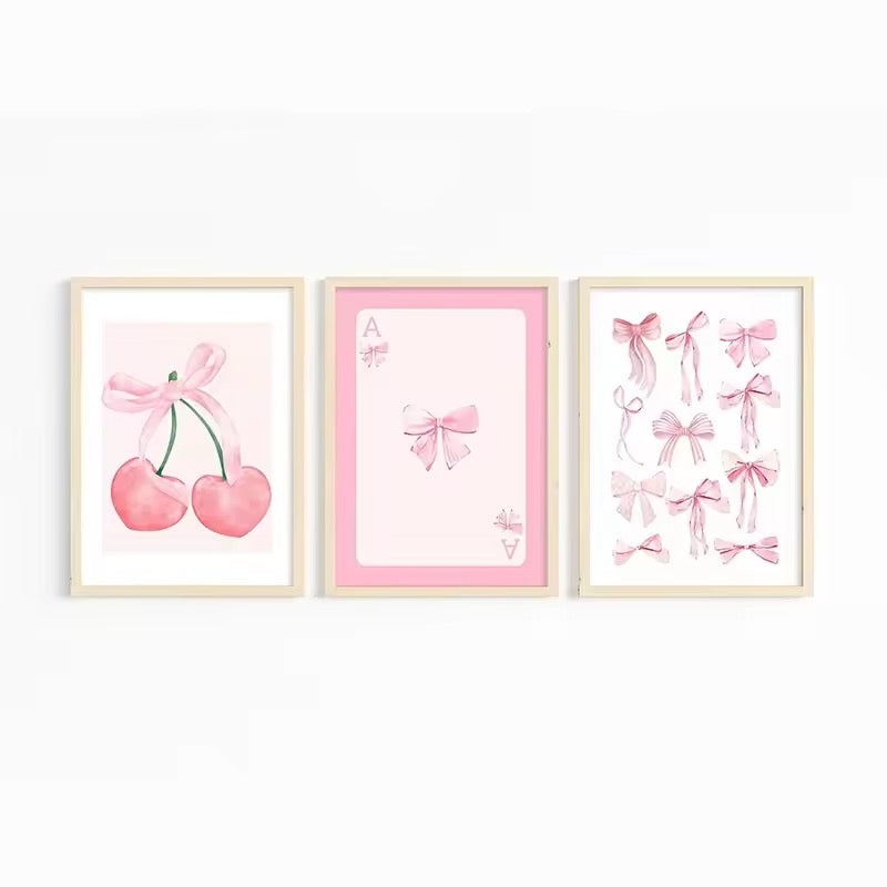 Close-up of pink watercolor bows canvas art framed on a pastel dorm wall.
