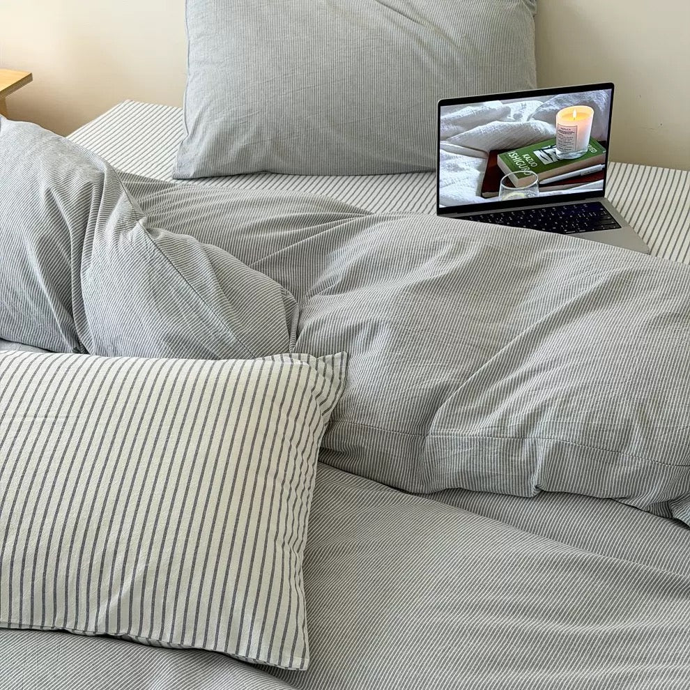 Korean minimal bedroom featuring light gray striped cotton bedding styled with clean furniture and warm ambient lighting.