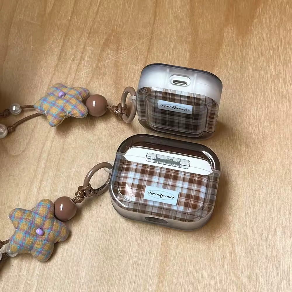 Two plaid-patterned cases with keychains on a wooden surface