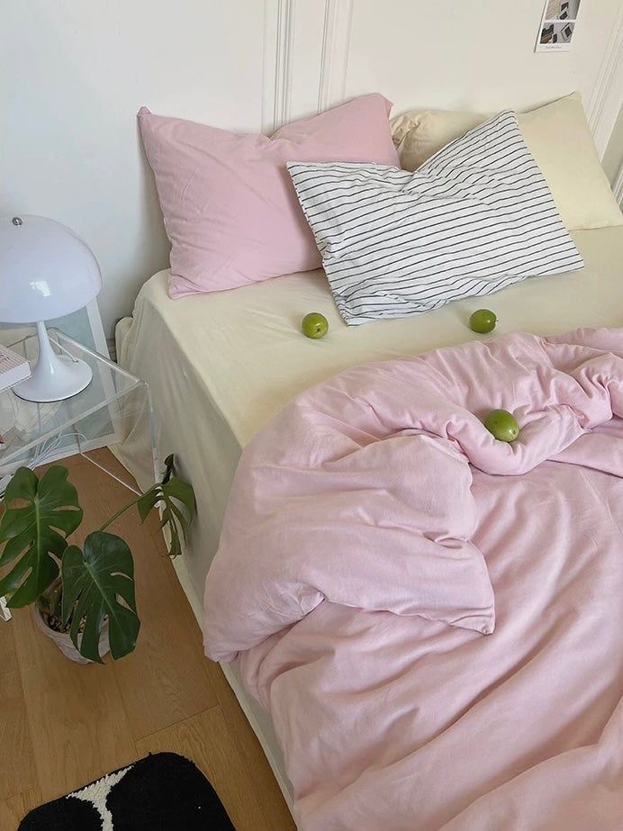 Solid pink cotton bedding with a cream sheet and cream-yellow pillowcase