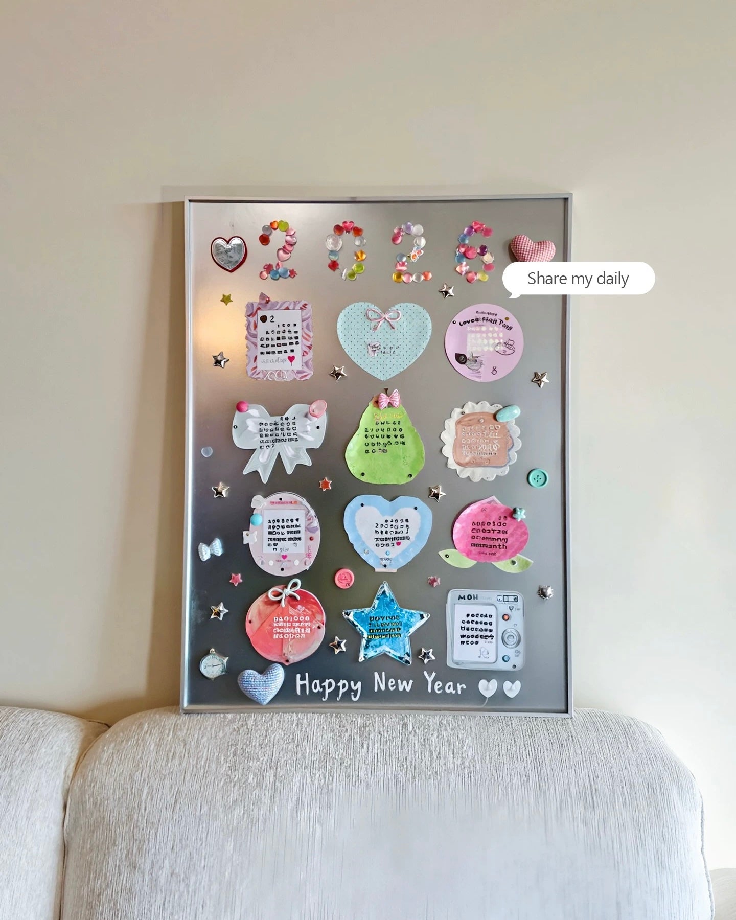 A framed personalized New Year 2024 display board with pastel stickers, notes, and decorative elements, mounted on a beige wall above a light-colored sofa. A 'Share my daily' speech bubble graphic is overlaid on the right.
