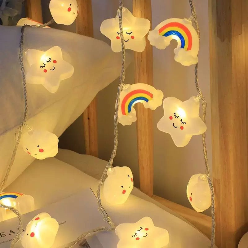 String lights with star and rainbow designs on a wooden surface.