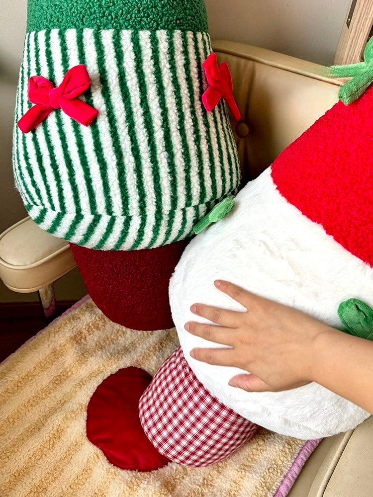 Close-up of green striped Christmas tree pillow with red bow details