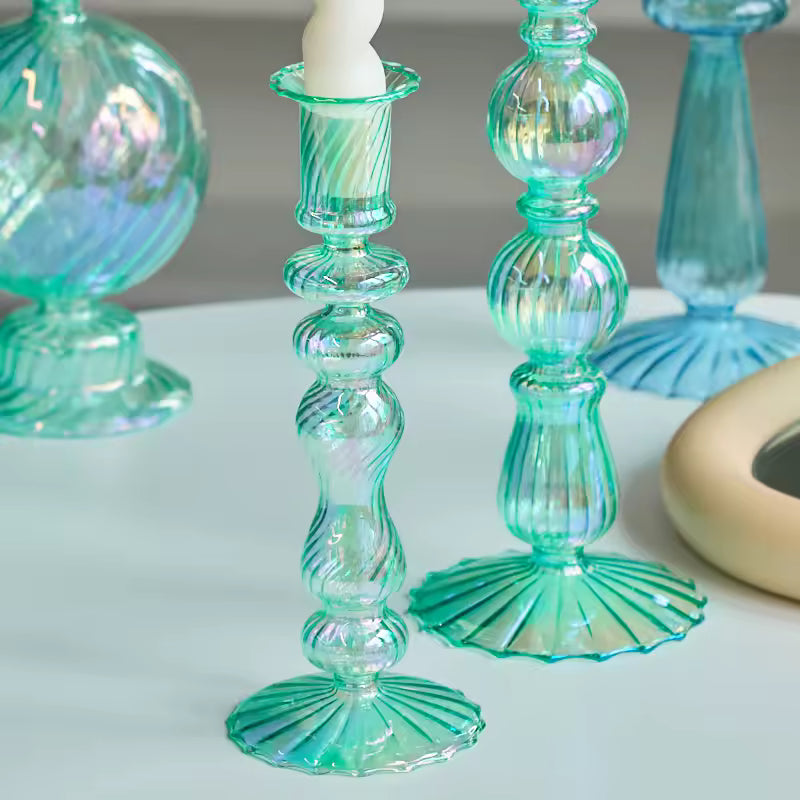 Collection of decorative glass candle holders and vases on a table.