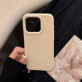 Beige phone case held by a person with a blurred background