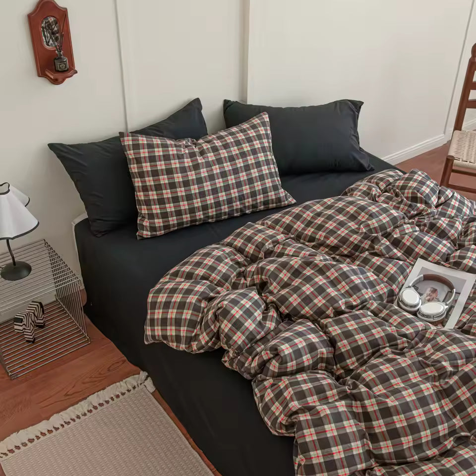 Bed with plaid comforter and pillows in a bedroom setting