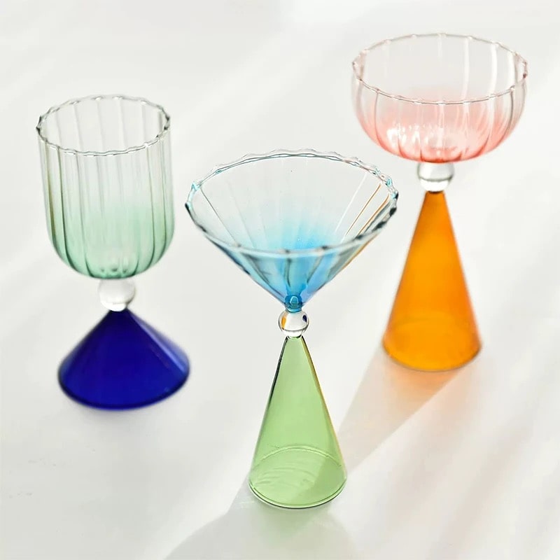 Clear cocktail glass with colored stem sections and polished gold rim shown from front view.
