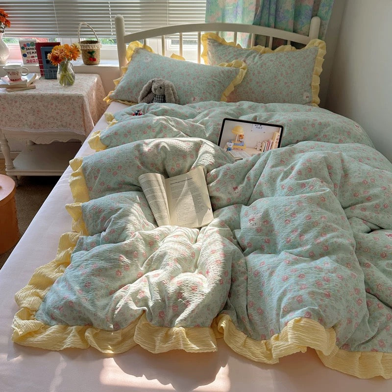 Floral pillowcase and blush pink sheet layered together on a cozy cottagecore styled bed
