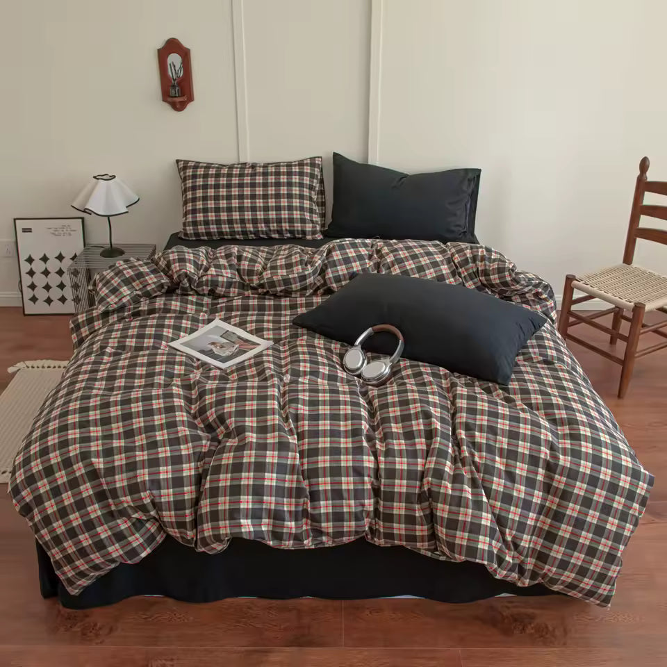 Plaid bedspread on a bed in a room with a chair and lamp.