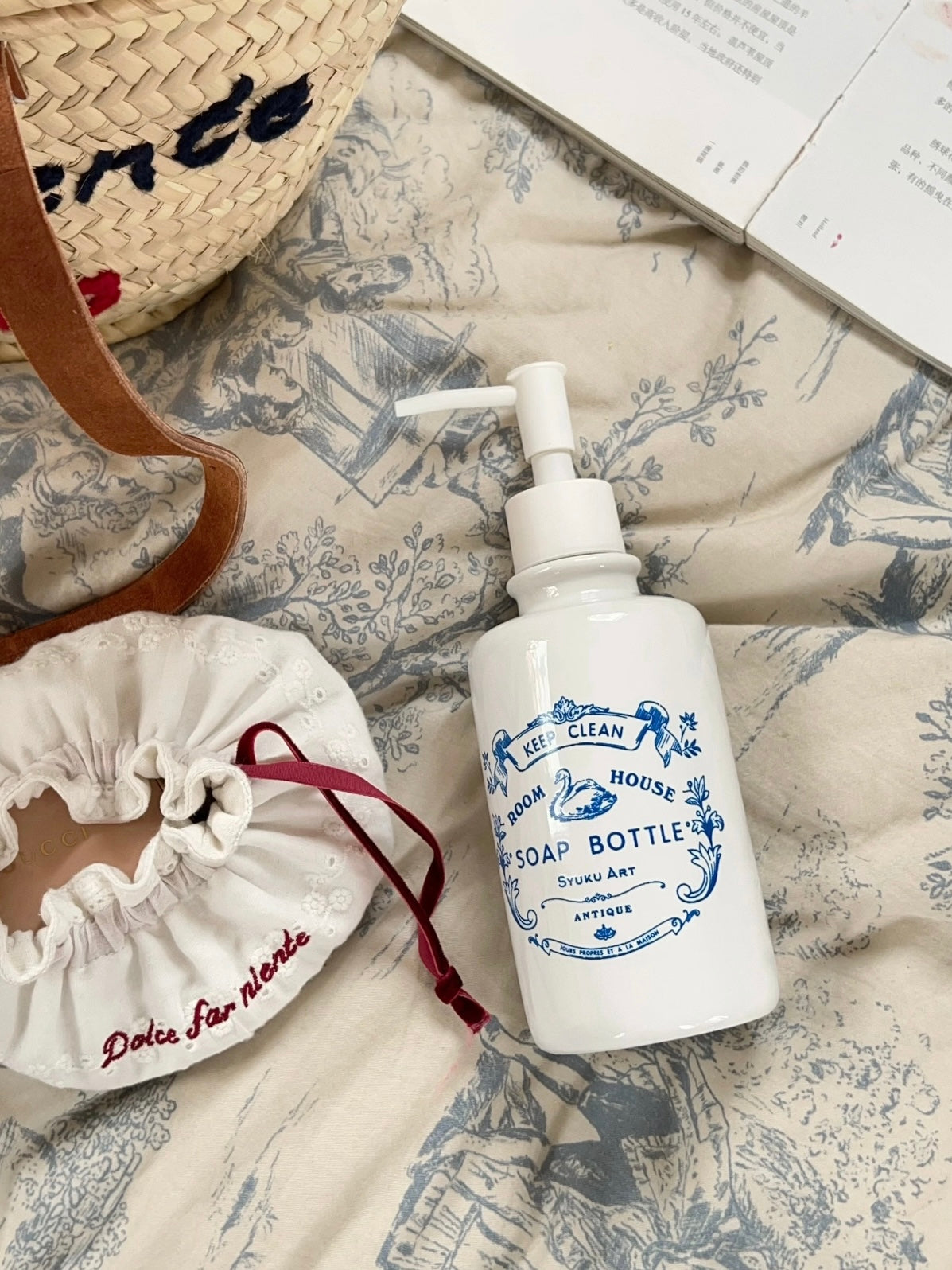 Vintage soap dispenser lies at an angle with its white pump and blue swan label visible on the bottle.