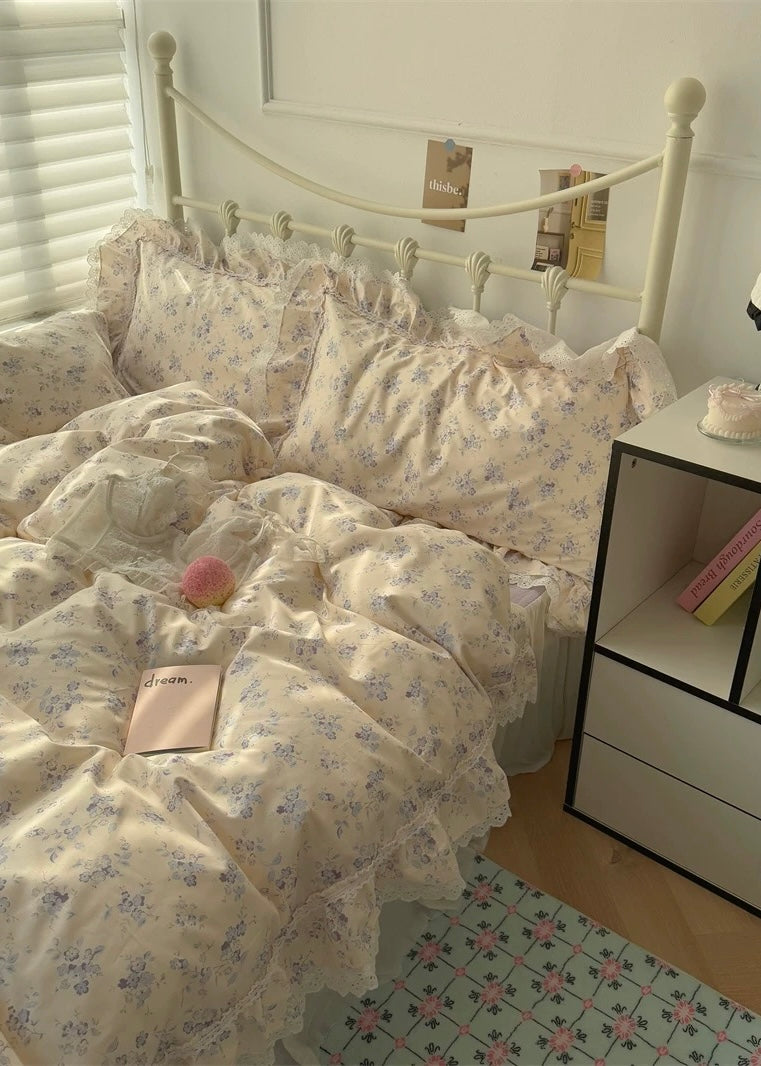 Bedroom with floral bedding and a nightstand.