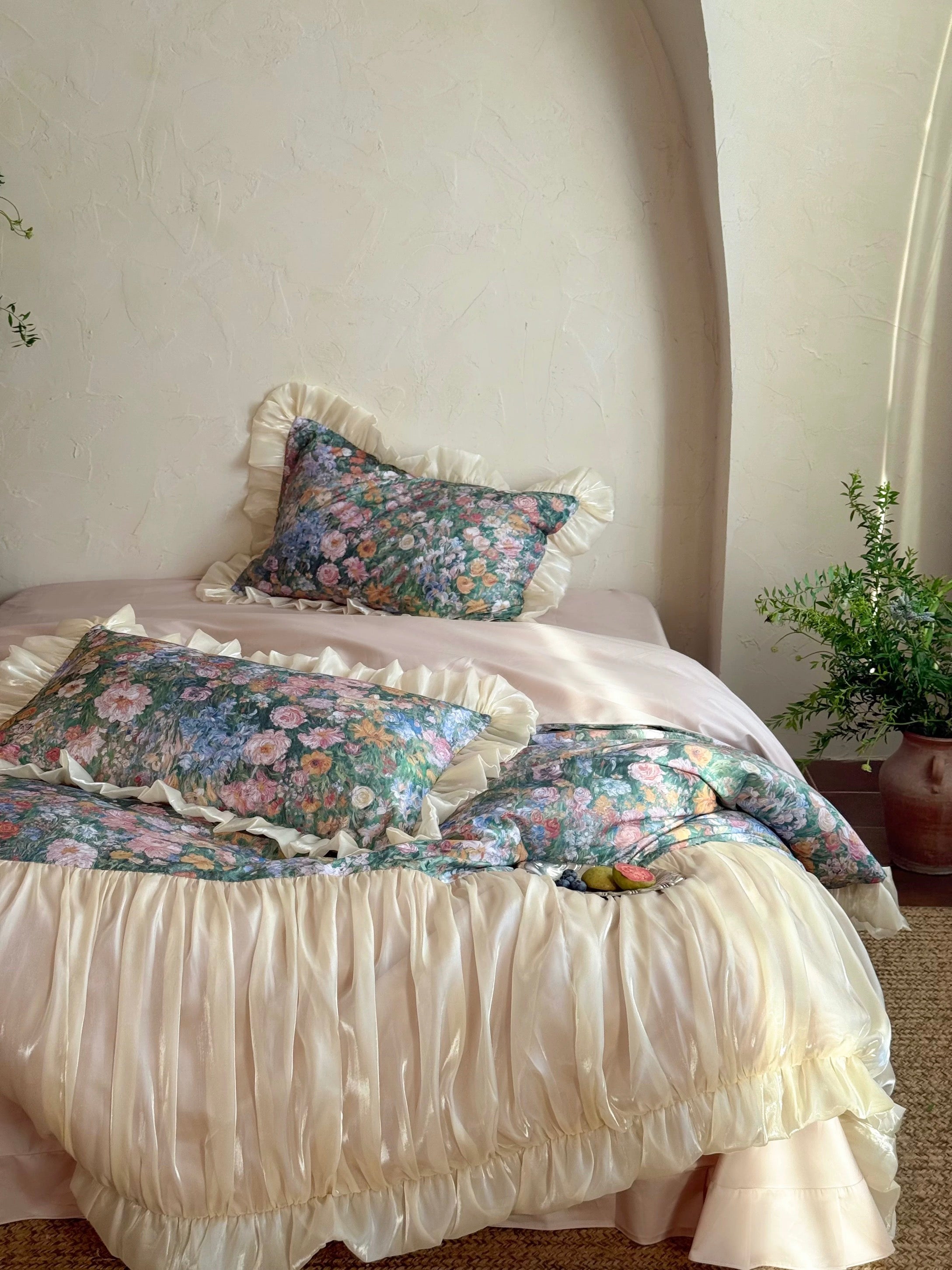 Bed with floral bedding and ruffled skirt in a bedroom setting