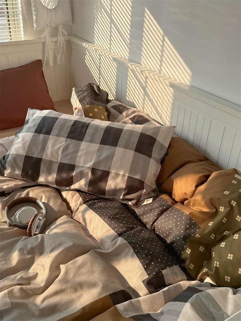 Bed with patterned bedding and pillows in a softly lit room.