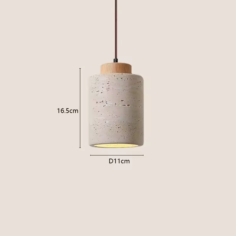 Scandinavian pendant lamp with cylinder stone shade styled over minimalist dining area and chairs.
