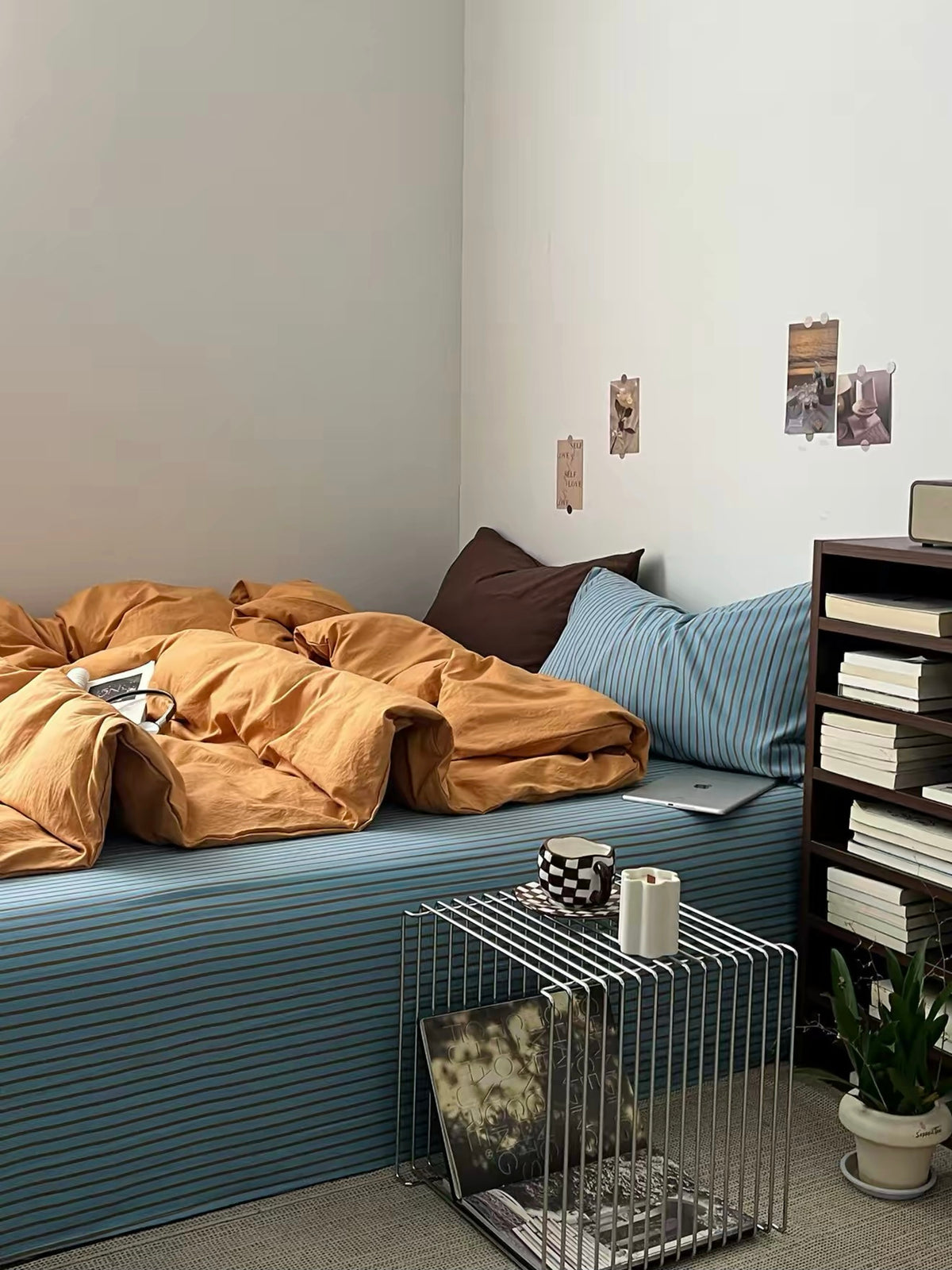 Wide bedroom view with the orange washed cotton bedding and blue striped sheet