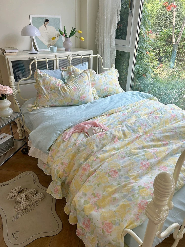 Pastel rose bedding with a light blue sheet in a cottagecore bedroom