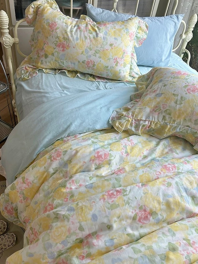 Close-up of watercolor floral pillows and light blue bedding