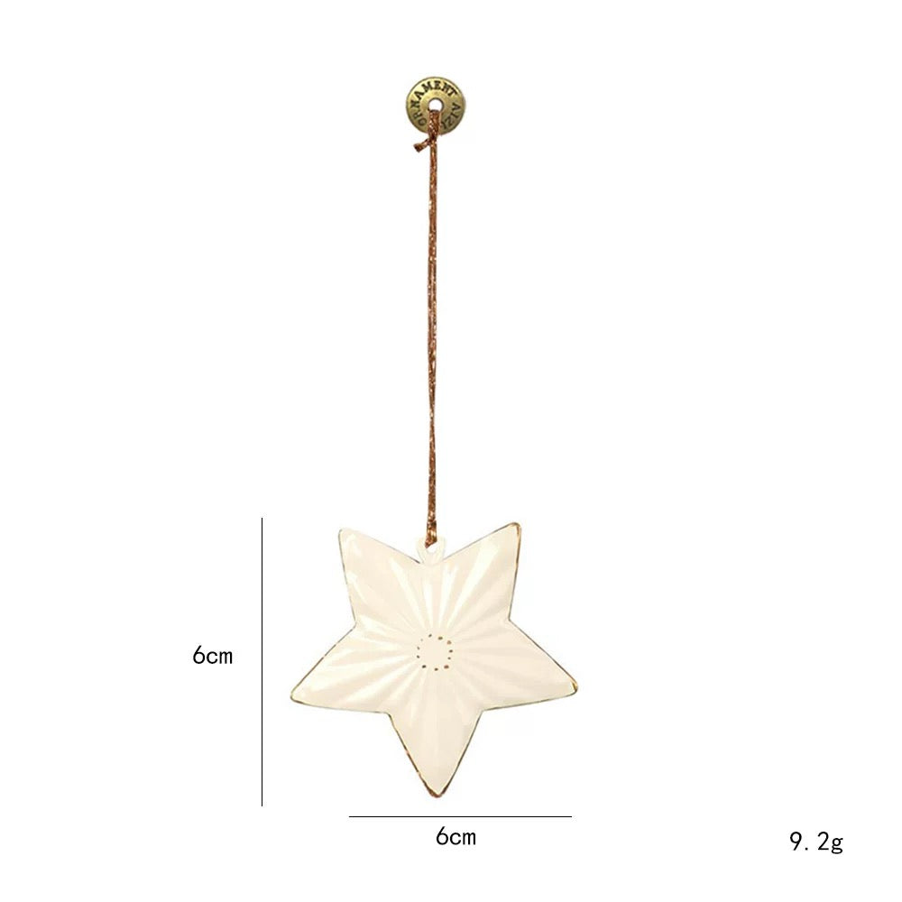 A white star metal Christmas ornament has raised sections and a fine gold colored edge around its points.