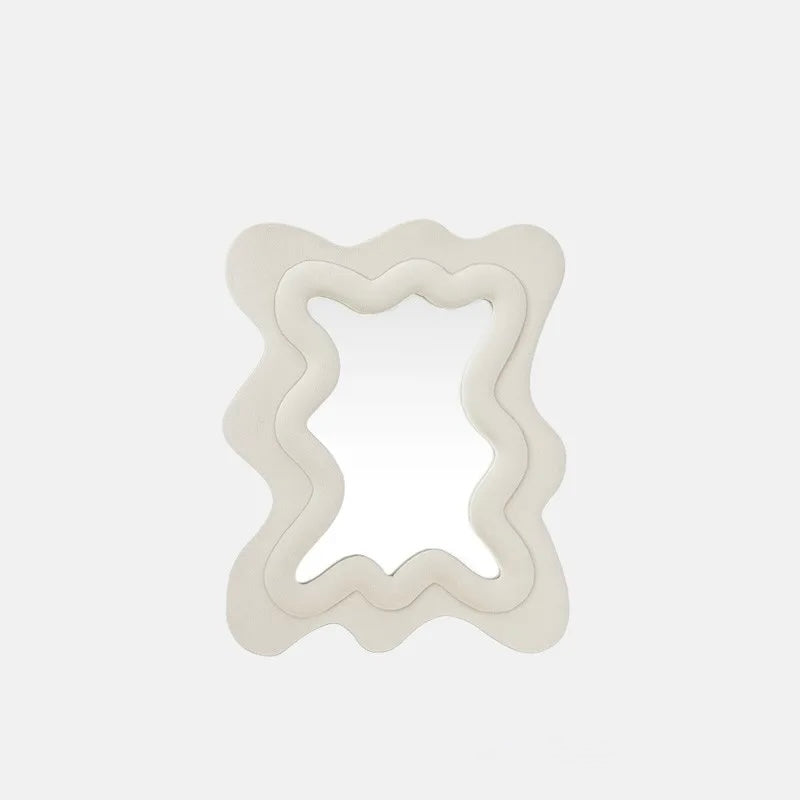 A wavy, double-layered decorative mirror with a thick, sculptural off-white frame, shown against a solid light gray background.