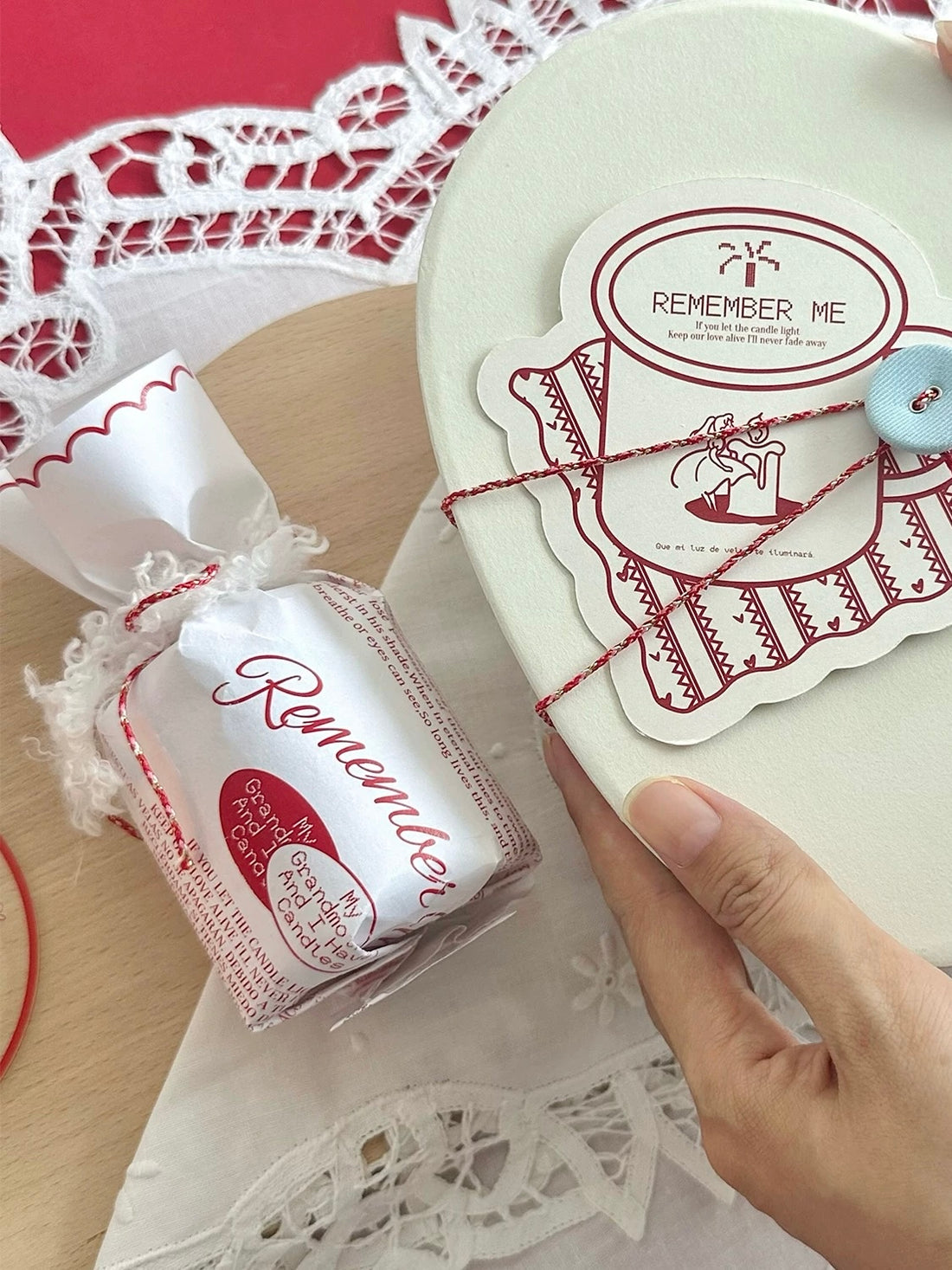 Wrapped Christmas scented candle held beside its gift packaging